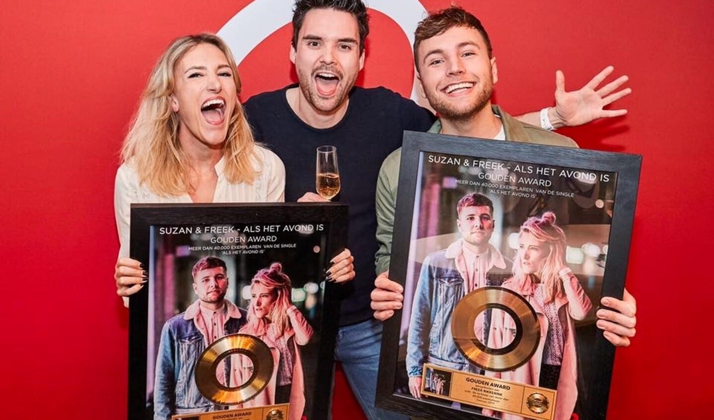 Suzan & Freek krijgen uit handen van Q Music-dj Domien Verschuuren een gouden plaat voor 40.000 verkochte singles van 'Als het avond is'. Foto: PR