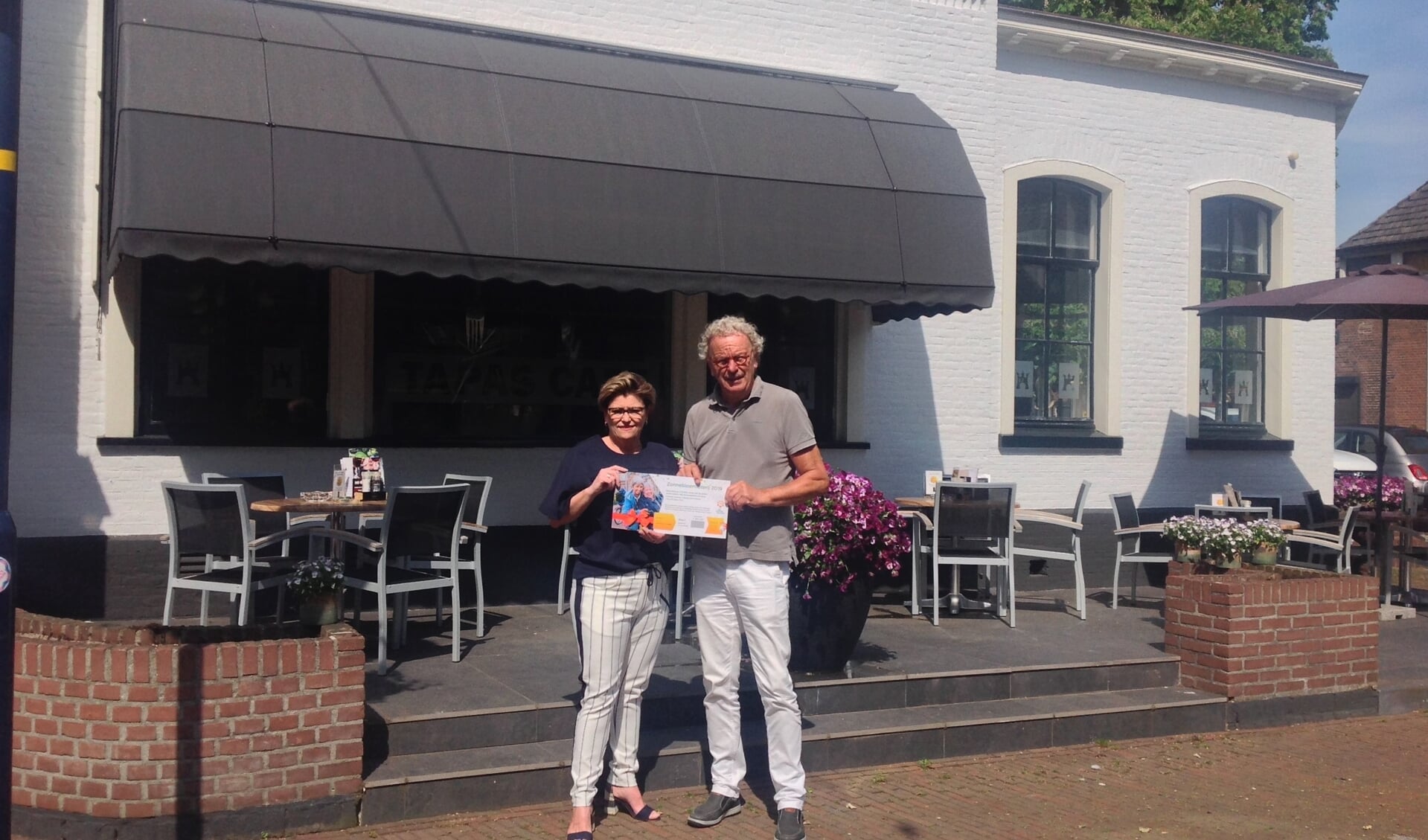 Henrike Lobbes van Hotel Avenarius gaf met de aankoop van loten van voorzitter Koos Luurs van de Zonnebloem Ruurlo de aanzet voor de loten verkoop. Foto: PR. 