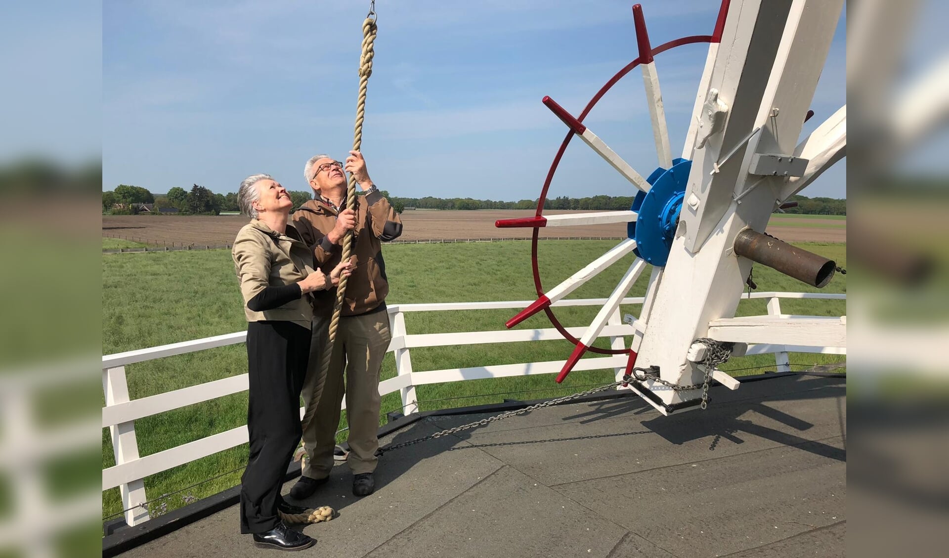 Wethouder Marijke van Haaren zet met molenaar Bennie Mensink de molen in werking. Nationale Molendag in Neede is met deze handeling geopend. Foto: PR