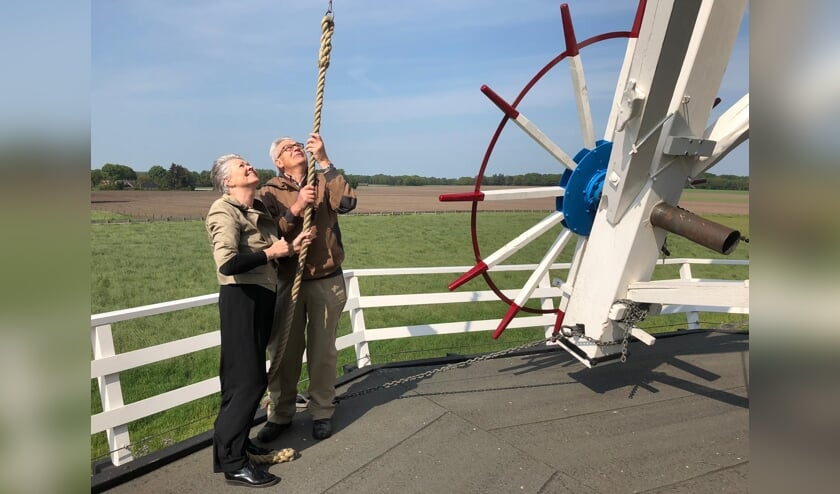 Wethouder Marijke van Haaren zet met molenaar Bennie Mensink de molen in werking. Nationale Molendag in Neede is met deze handeling geopend. Foto: PR