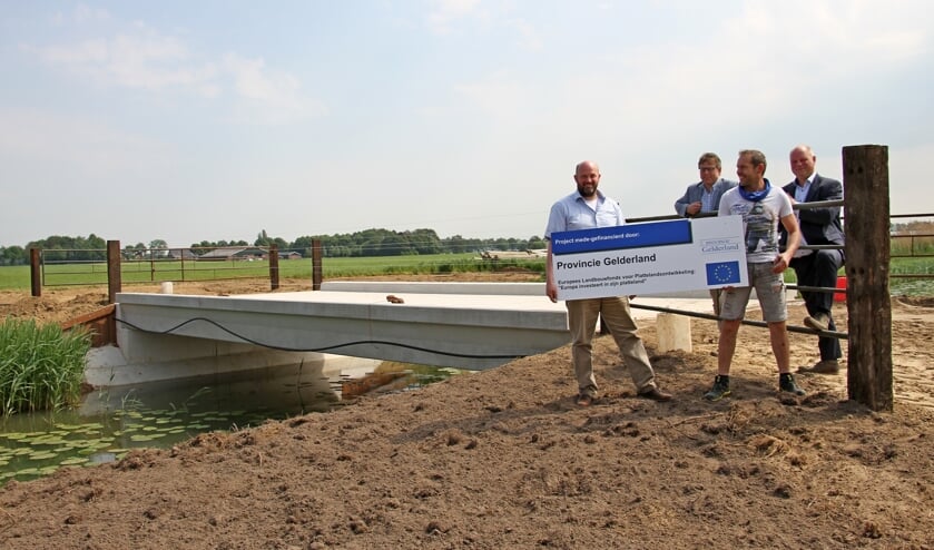 Hans Lamers, Marcel Schiphorst, Henry Pardijs en Peter Schrijver plaatsen het bord bij de gerealiseerde brug over de Grote Beek. Foto: Liesbeth Spaansen