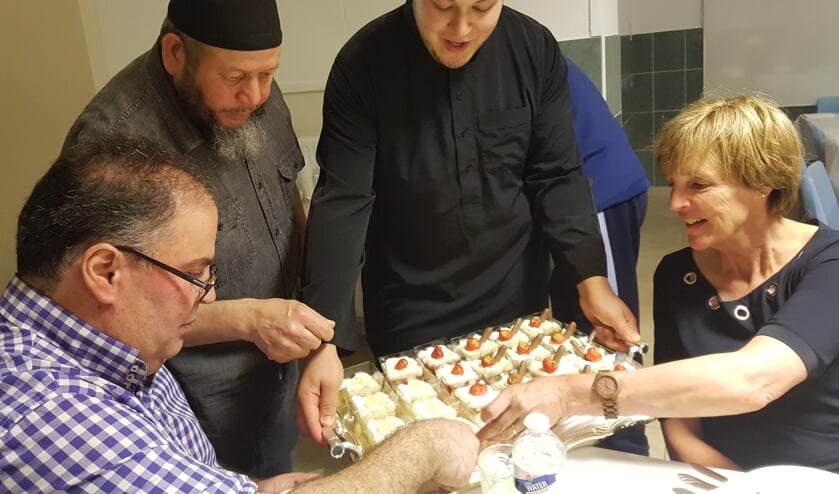 Burgemeester Bronsvoort krijgt van kok Yassin een dessert aangeboden. Links Boukhiyar Taouil. Foto: Kyra Broshuis
