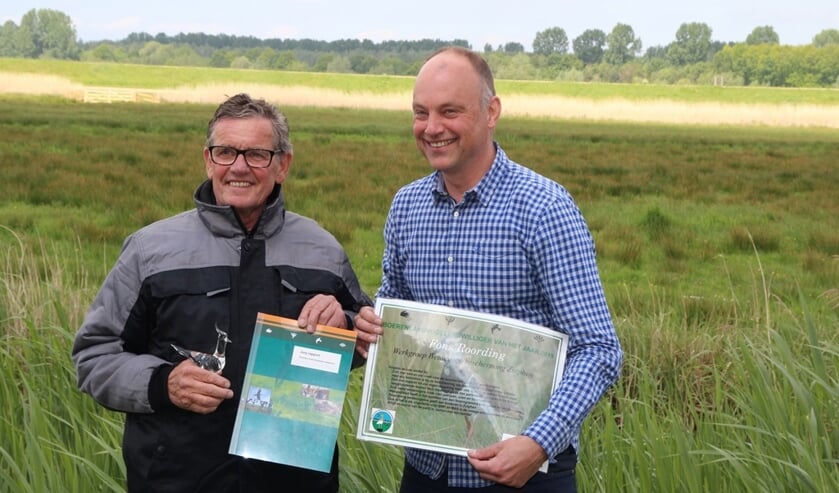 Boerenlandvogelvrijwilliger Fons Roording (l) ontvangt glazen kievit en een oorkonde uit handen van Arjan Vriend, directeur-bestuurder Stichting Landschapsbeheer Gelderland. Foto: SLG