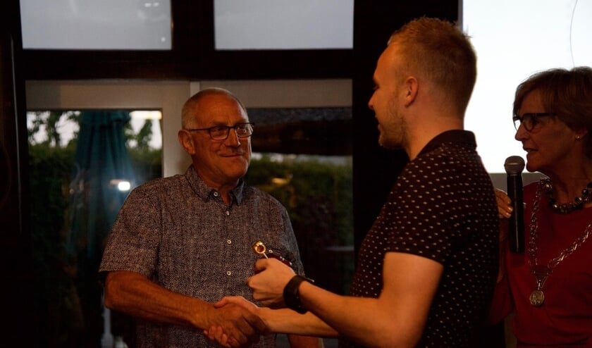 Michiel feliciteert zijn vader Tonnie Krabbenborg met de gouden fluit onder toeziend oog van burgemeester Bronsvoort. Foto: Lotte Bekkenutte