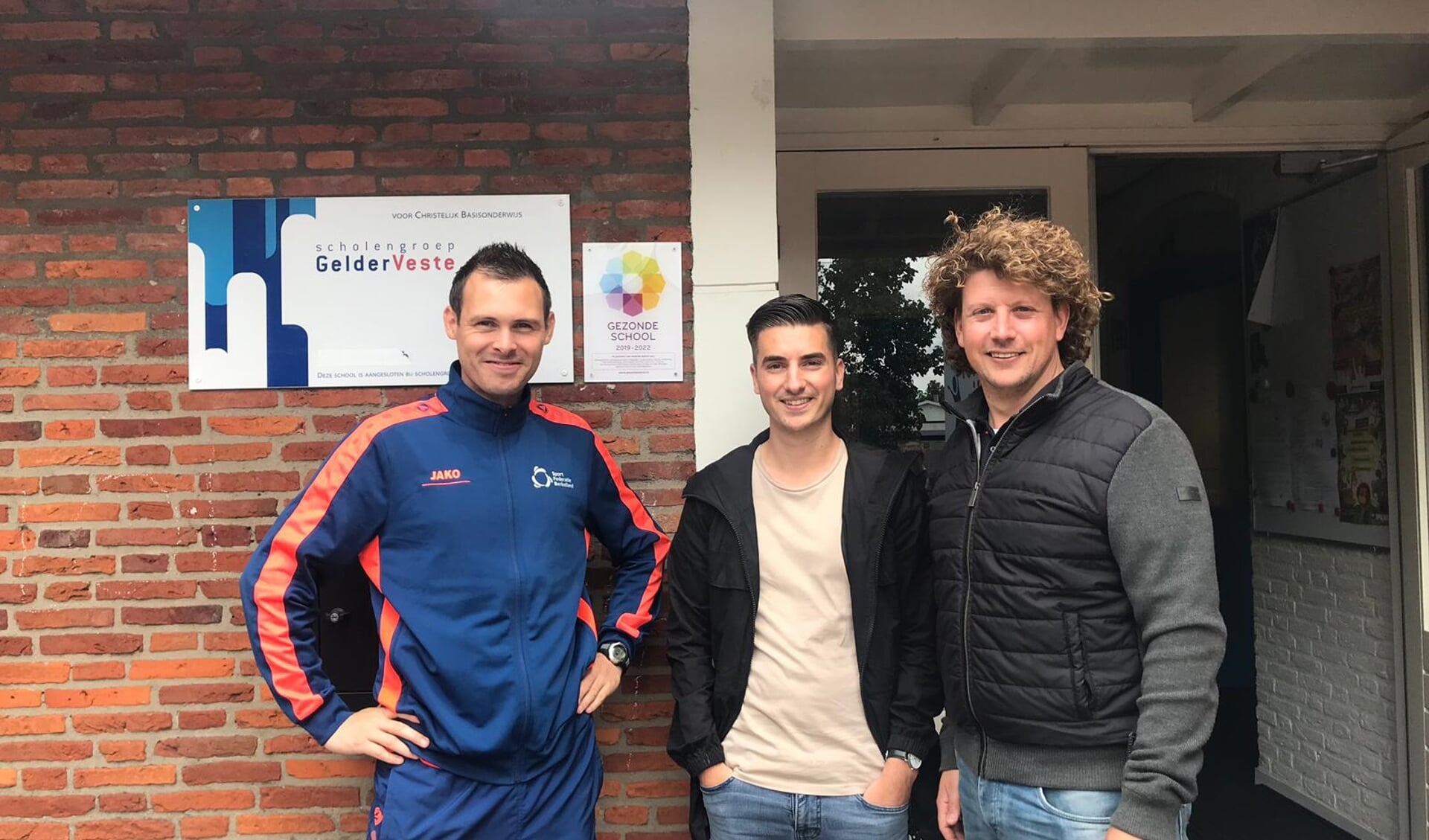 Troy IJsselstijn (Gezonde School Adviseur, GGD-Oost Nederland) en Dennis Krol (Sportleerkracht, Sport Federatie Berkelland) hebben samen met de directeur Rutger Slot-de Vries en leerlingen het logo onthuld. Foto: PR