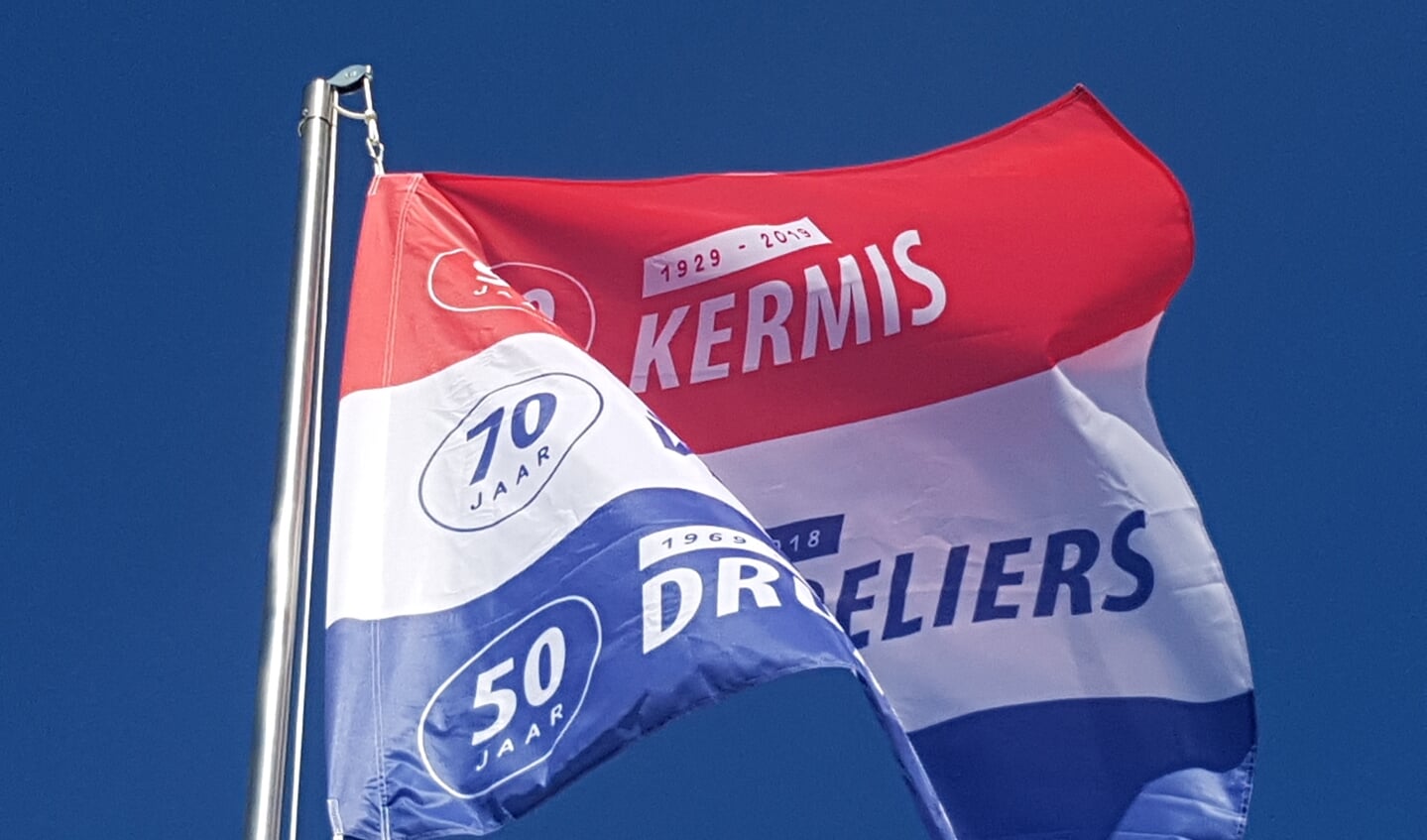 De speciaal ontworpen jubileumvlag wappert boven het kermisterrein in Lievelde
