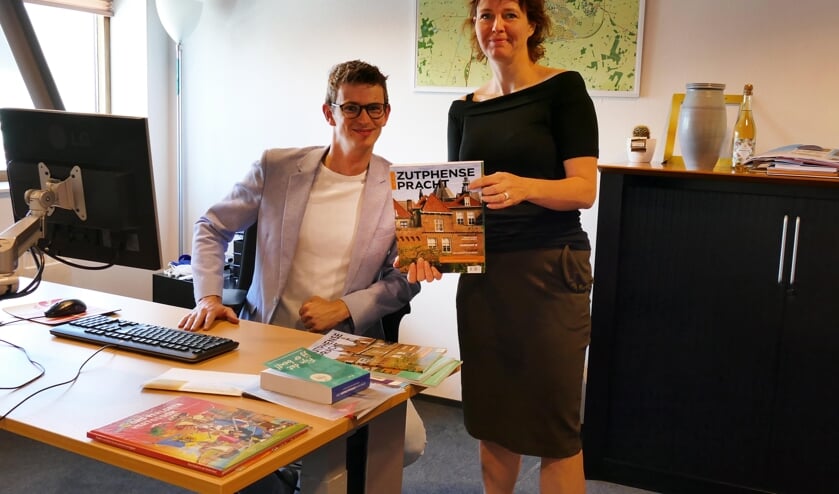 Hoofdredacteur Brigiet Bluiminck wethouder Mathijs ten Broeke op zijn werkkamer met de nieuwste editie van Zutphense Pracht. Foto: PR