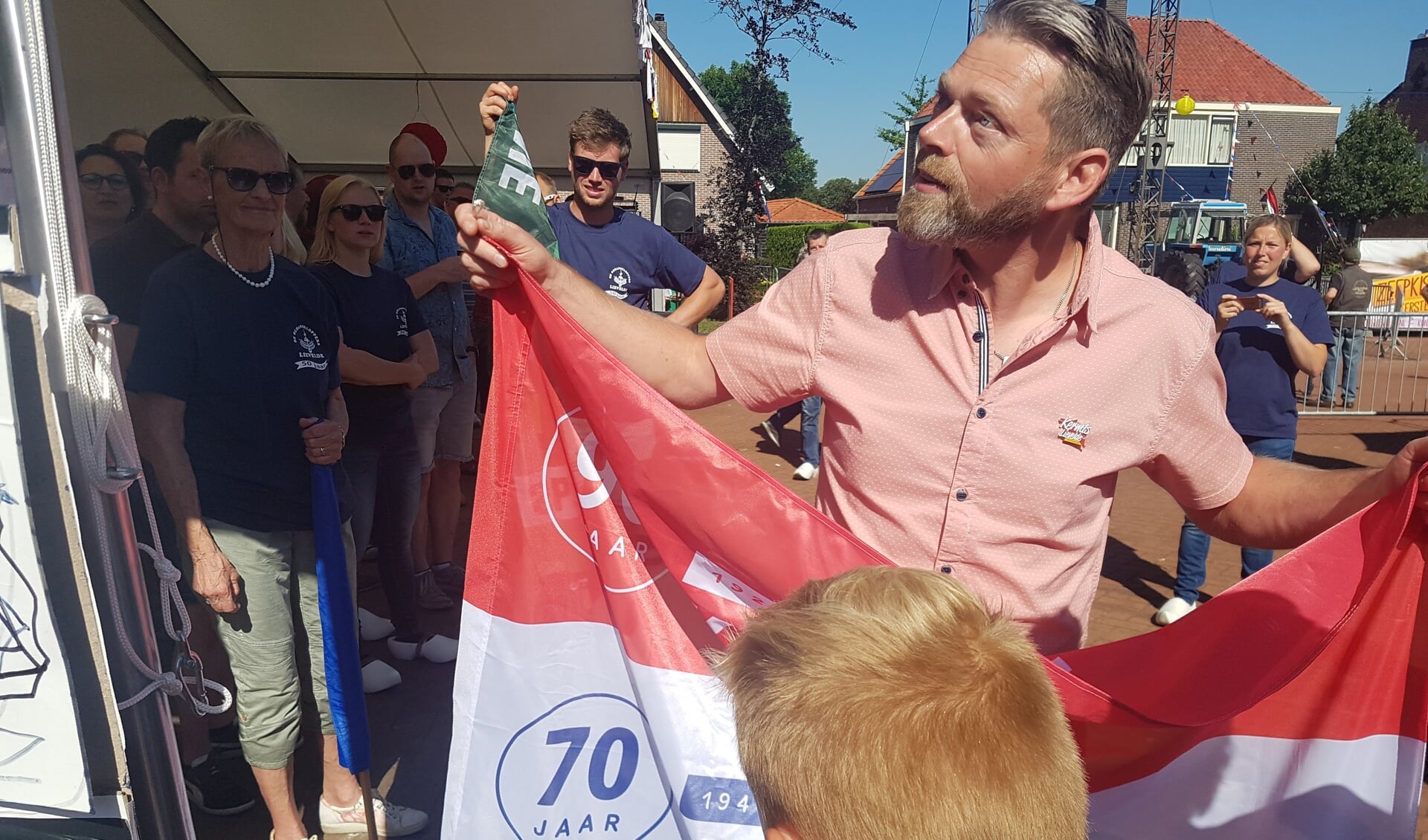 Coen Arink van de Stichting School en Volksfeest Lievelde staat op het punt de vlag te hijsen. Foto: Kyra Broshuis