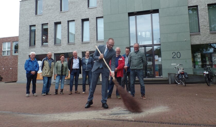 Met een aantal flinke vegen met een berkenbezem opende wethouder Gerjan Teselink op het Kerkplein de fototegelroute. Foto: Jan Hendriksen.