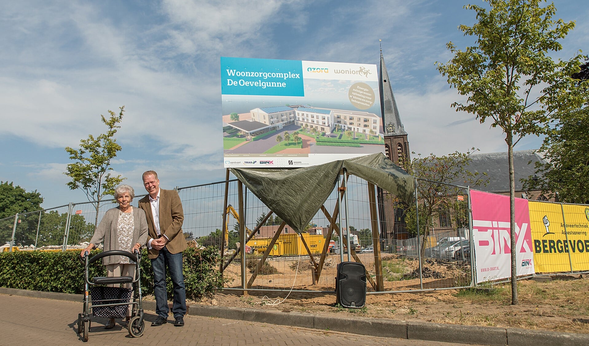 Mevrouw van der Hoorn heeft het bouwbord en daarmee de nieuwe naam onthuld: De Oevelgunne. Foto: Gewoon Hekman