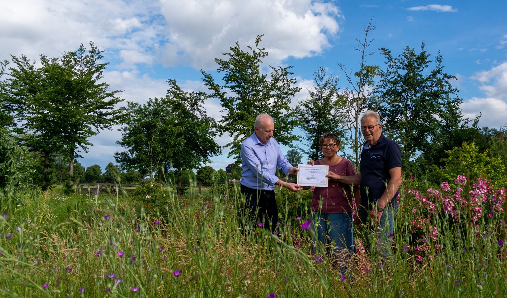 De eerste prijs in de tuinverkiezing wordt uitgereikt door Groei&Bloei-voorzitter Frans Beijerling, Rechts het echtpaar Duitshof. Foto: Ronald Duitshof