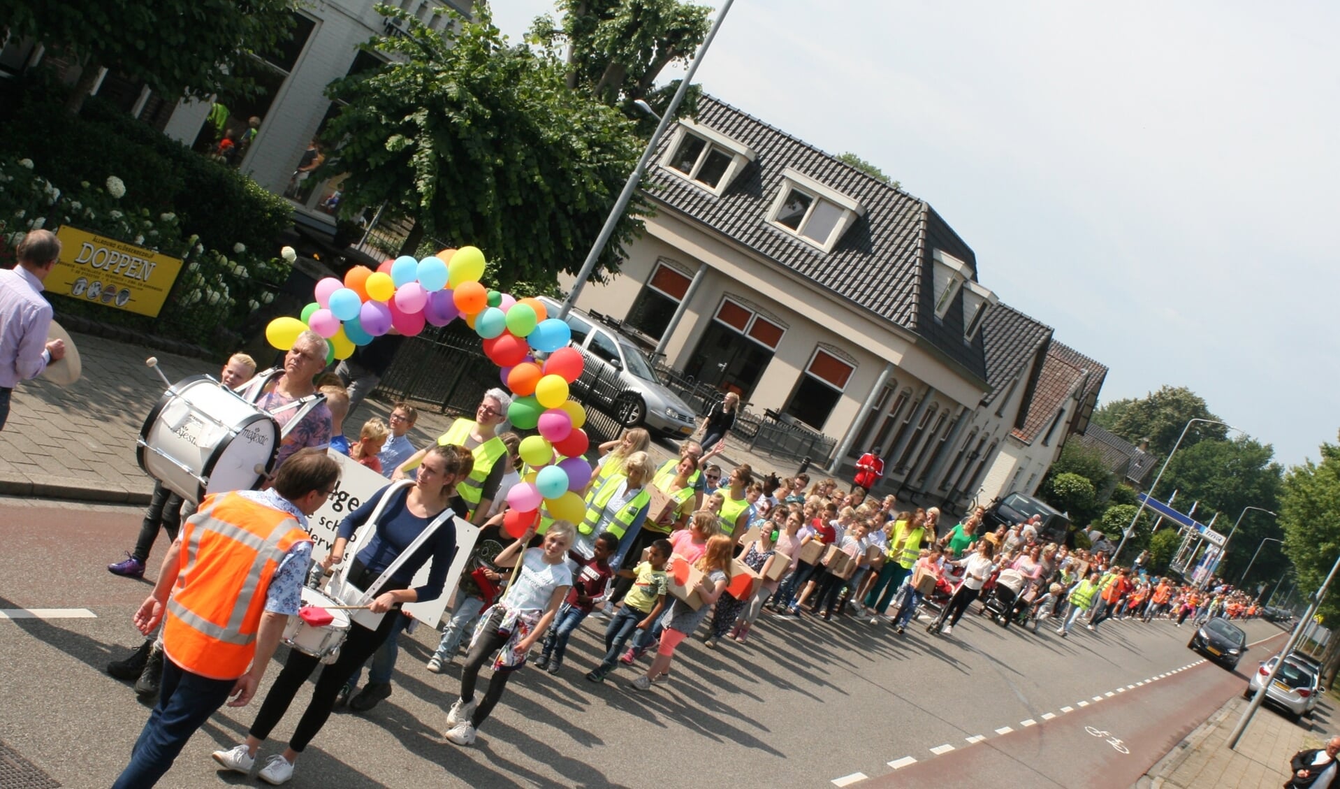 De leerlingen vormen een kleurige stoet die over de Varsseveldseweg trekt. Foto: Jos Betting
