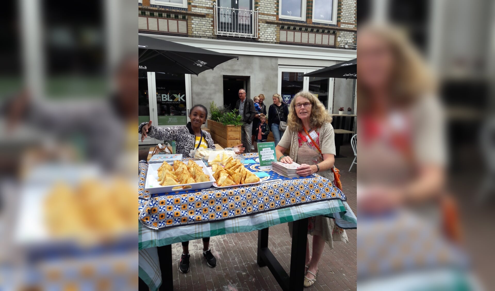 Vol trots laat een van de deelnemers aan het Taalcafé de baksels zien. Foto: eigen foto