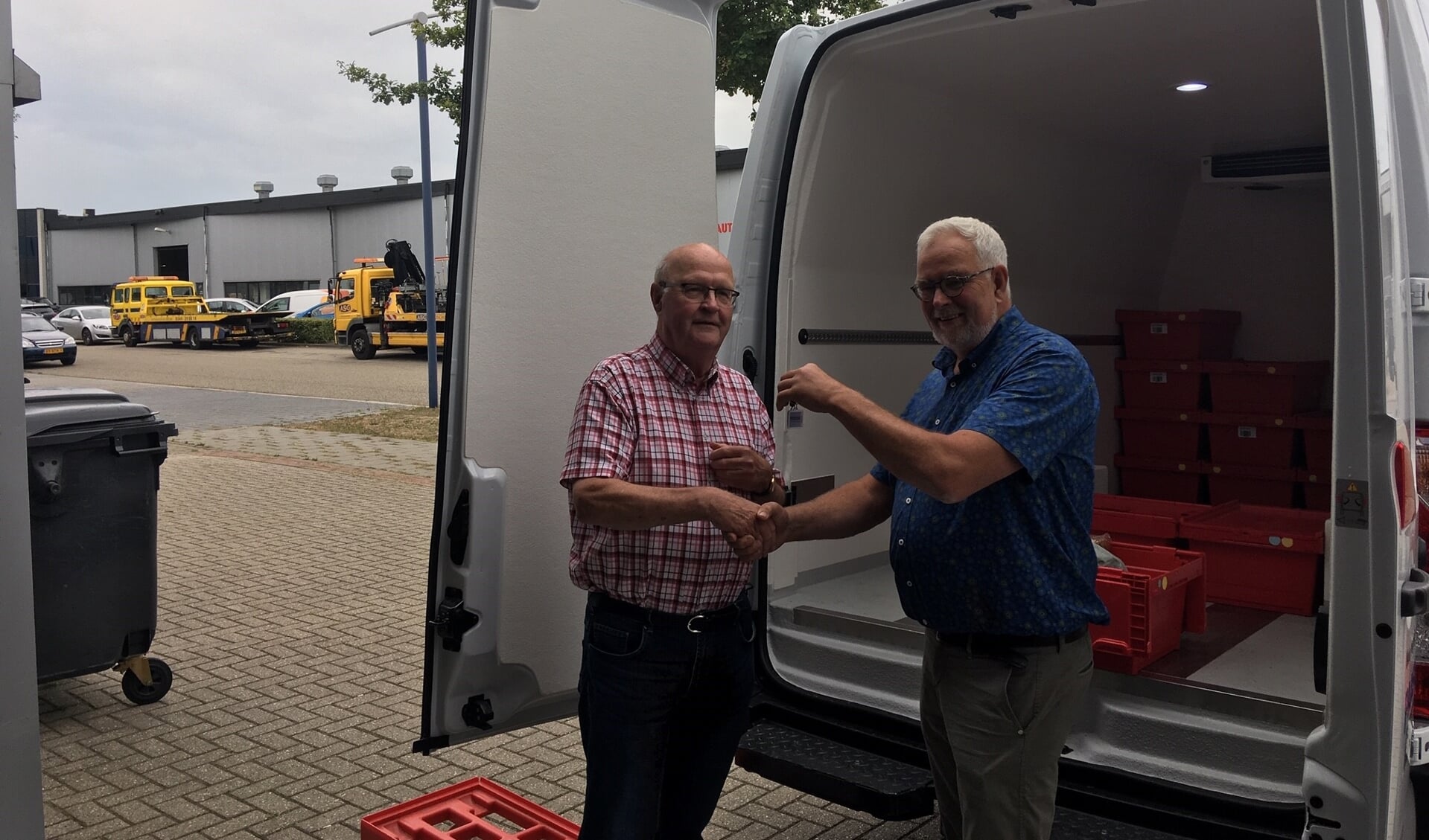 Voorzitter Chris Blaauboer neemt de sleutel van de nieuwe bus in ontvangst van Hans Tijdink. Foto: Barbara Pavinati