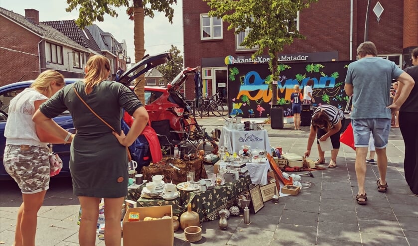Ook particulieren boden spullen aan vanuit de kofferbak. Op de achtergrond wordt samen met kinderen gewerkt aan een graffiti. Foto: Janette van Egten