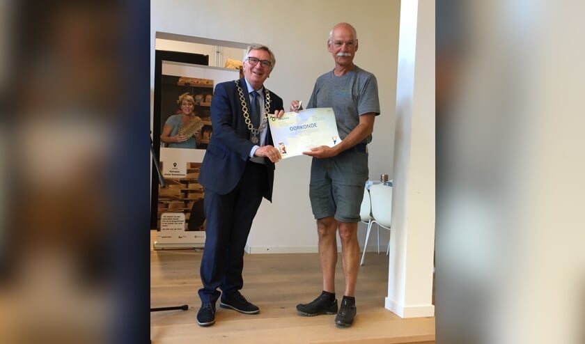 Henk Vriend uit Vorden ontving een oorkonde en erespeld uit handen van burgemeester Geert van Rumund van Wageningen. Foto: PR