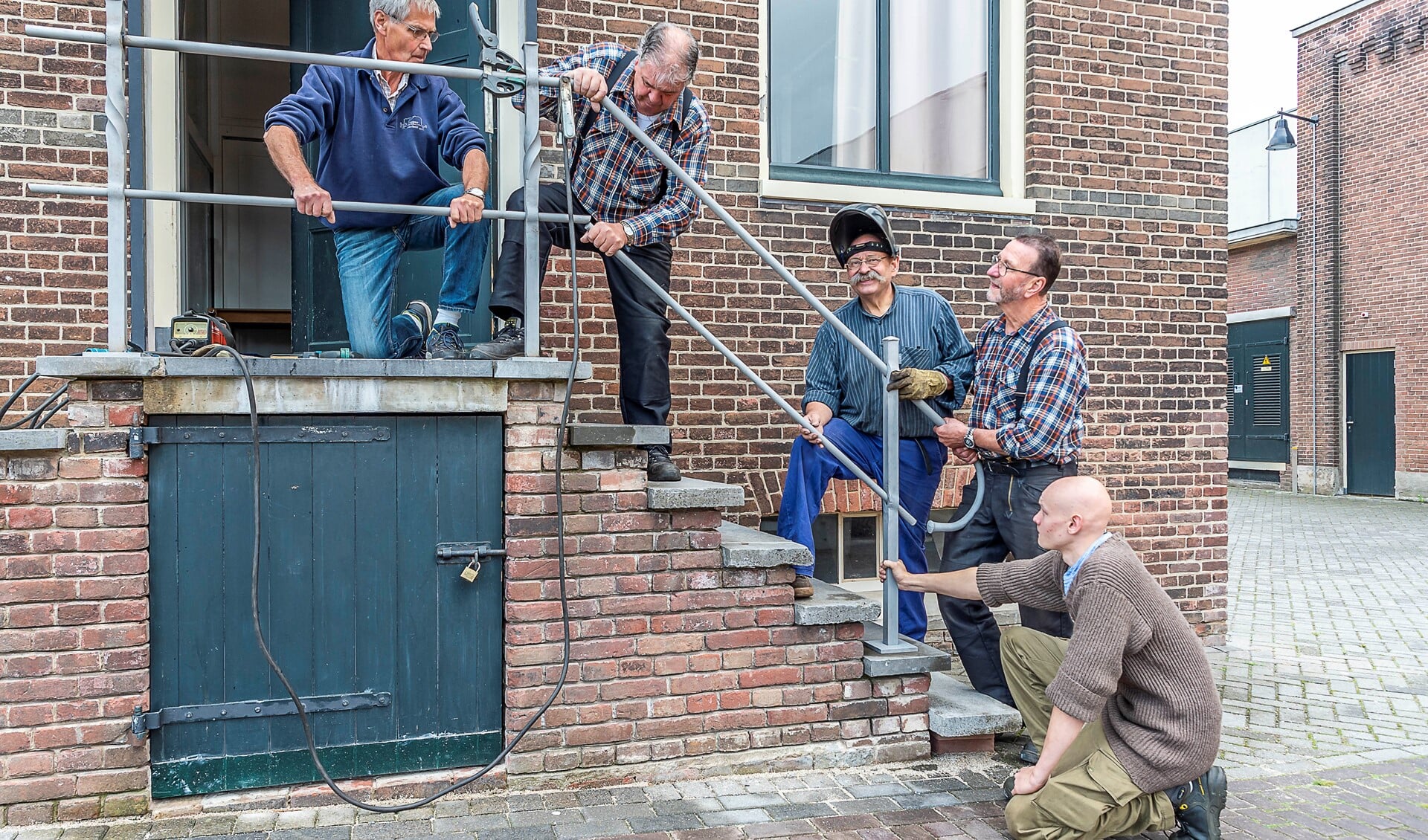 De smeden leggen de laatste hand aan het ambachtelijk vervaardigde  nieuwe hekwerk bij het ketelhuis. Foto: Henk van Raaij
