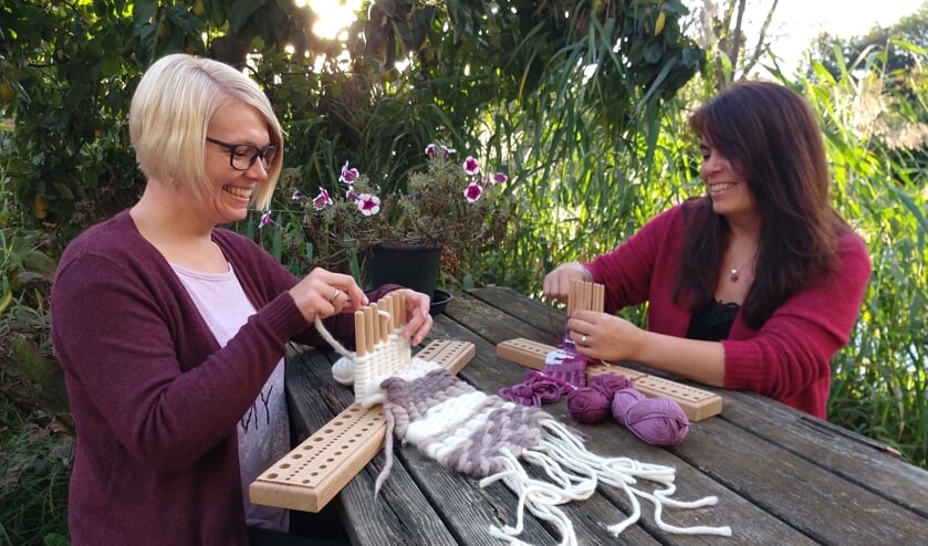 Sandra en Monique geven een demonstratie 'peg loom', stokjesweven. Foto: PR