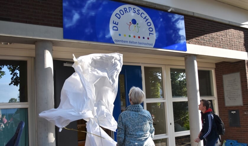 De taak van Leontine en Wessel zit erop. Het nieuwe logo van De Dorpsschool is onthuld. Foto: Alice Rouwhorst