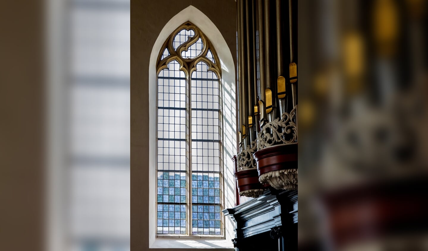 Een van de twee kleine gerestaureerde ramen met op de voorgrond het orgel dat groot onderhoud kende. Foto: Henk Droppers. 