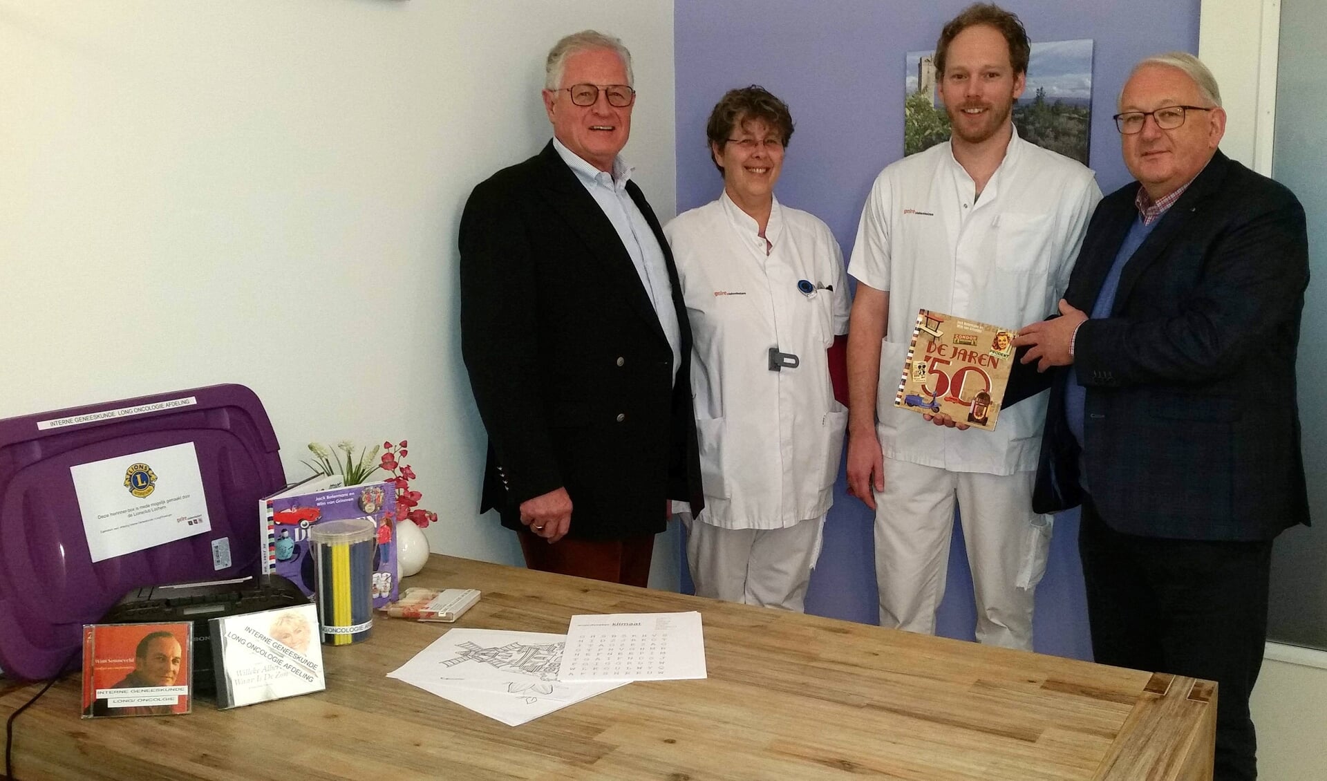 Voorzitter en secretaris van de Lions Club Lochem en omstreken schenken verpleegkundigen van het Gelre Zutphen een herinnerbox voor patiënten. Foto: Gelre Ziekenhuizen