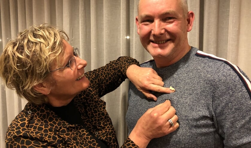 Arnold krijgt de onderscheiding opgespeld door zus Brigitte, ook collega-muzikant. Foto: PR