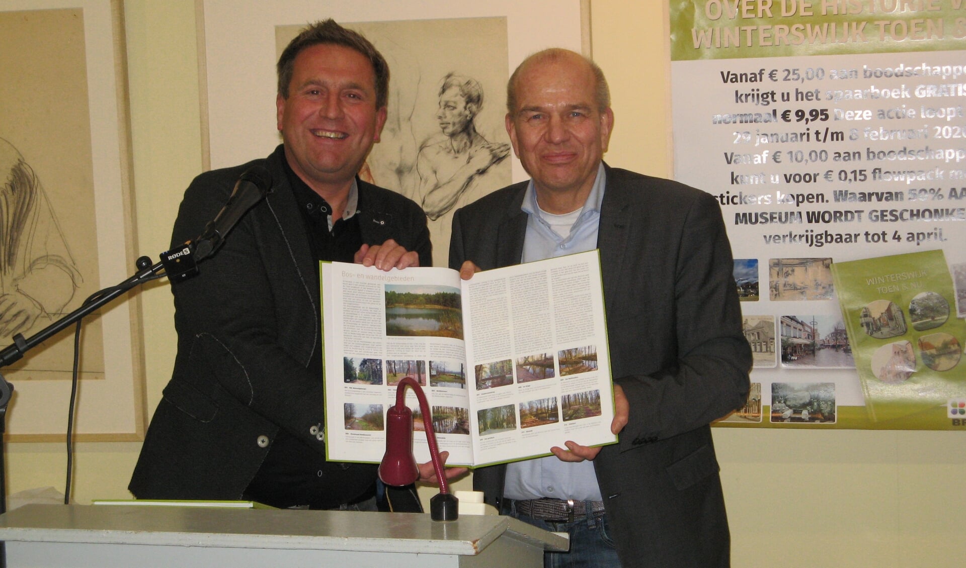 Jeroen Bruggers (links) overhandigt wethouder Wim Aalderink het eerste exemplaar van 
