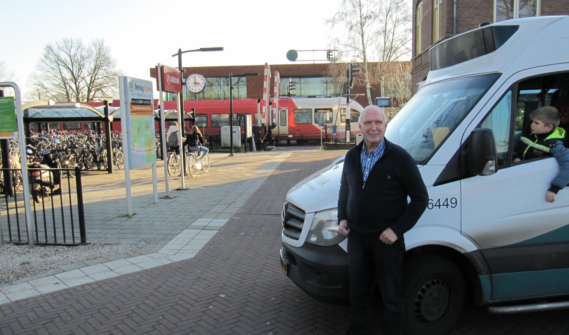 Henk wacht bij station Aalten zoals altijd op de aansluitende treinen. Kleinzoon Twan ziet de buurtbus wel zitten. Foto: PR