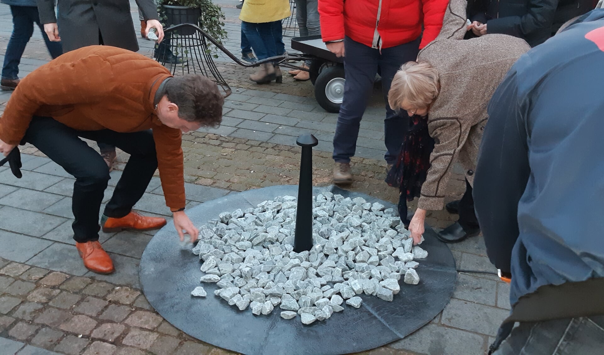 De stenen worden op het tijdelijk monument op de Markt geplaatst. Foto: Ferry Broshuis