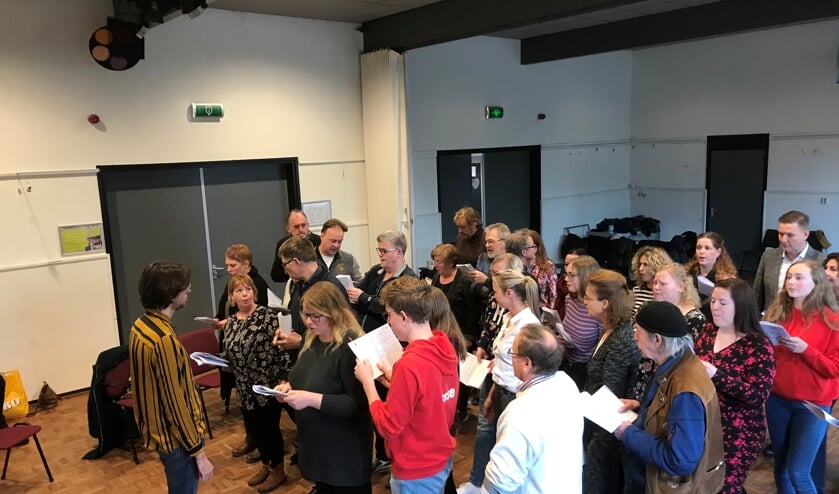 Stan Geurts (met gestreepte blouse) laat de groep een canon zingen.