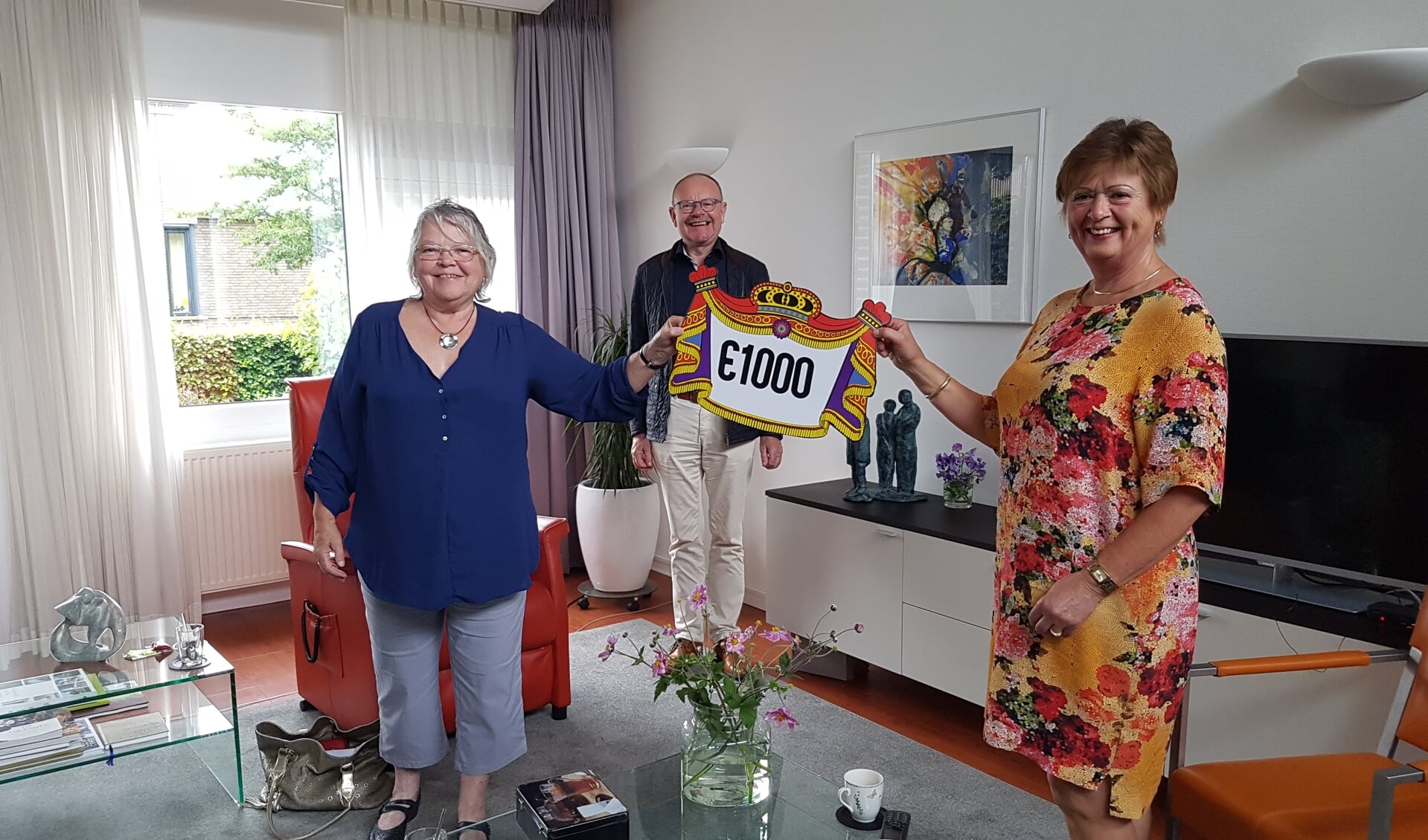 Maya Kuit (links) en Lyda Middelkoop overhandigen namens KVW de cheque van 1000 euro aan Johan Teeuwsen van Hospicegroep De Lelie. Foto: PR Hospicegroep De Lelie