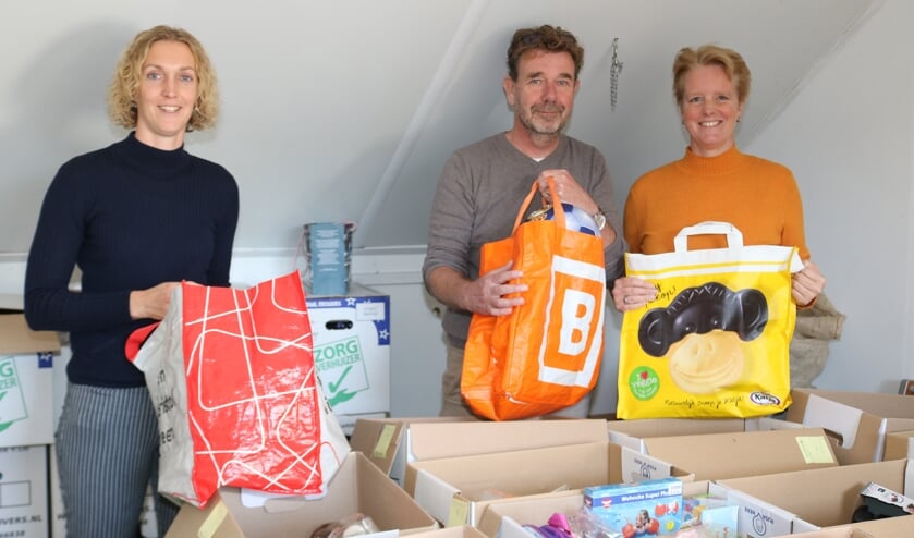 <p>Maaike van 't Oever en Henk en Trudy Koning ter Heege op zolder waar alles klaar staat voor pakjesavond. Foto: Arjen Dieperink</p>