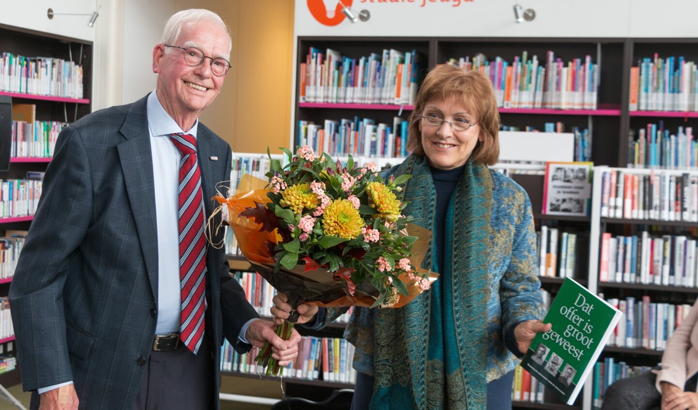 Auteur Ina Brethouwer ontvangt het boek en een boeket uit handen van Henk Mulder. Foto: Henk Derksen