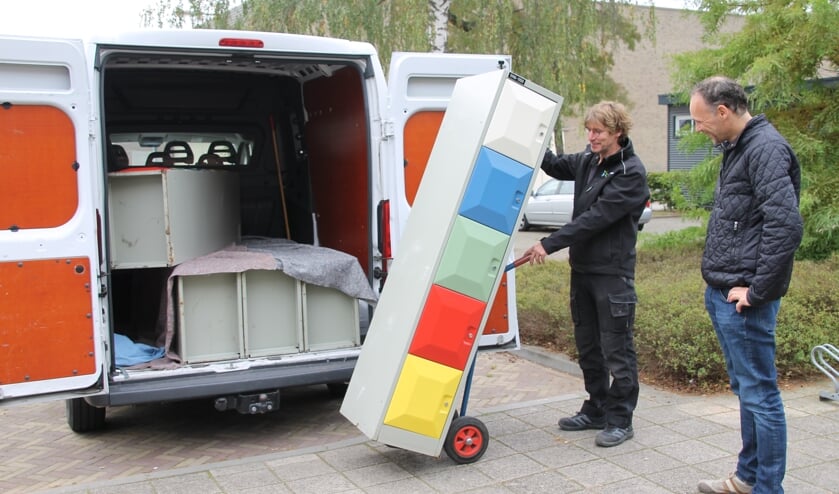 <p>Congiërge Gerard Ligtlee laadt de kleurrijke lockerkastjes uit onder toeziend oog van penningmeester Bart van 't Hooft. Foto: Annekée Cuppers</p>