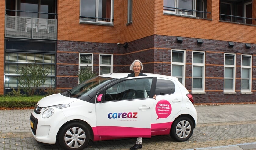 <p>Liedy Vennegoor met een auto met het nieuwe logo. Foto: PR</p>
