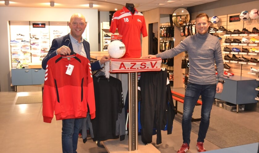 <p>Patrick Frenken met Stijn ter Haar in de 'shop-in-shop' met AZSV-artikelen. Foto: Karin Stronks</p>