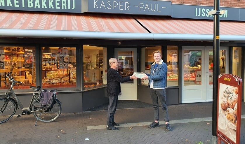 Manus Kamink krijgt de taart van Banketbakkerij Kasper Paul. Foto: PR