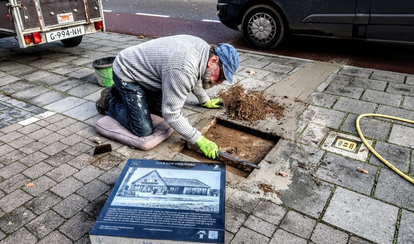<p>Harry Jansen – voorzitter van de stichting Tegelroute Bronckhorst – maakt plek voor een historische tegel aan de Hummeloseweg in Hengelo, waar in 1937 autogarage Herwers begon. Foto: Luuk Stam</p>