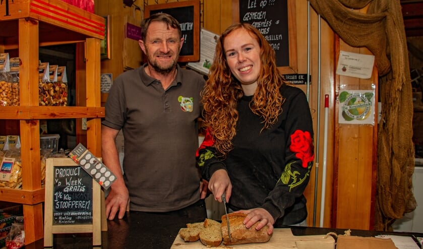 Iris Garritsen snijdt onder toeziend oog van vader Dick, het net afgebakken ambachtelijke brood aan in Boerderijwinkel De Kruisbrink. Foto: Liesbeth Spaansen