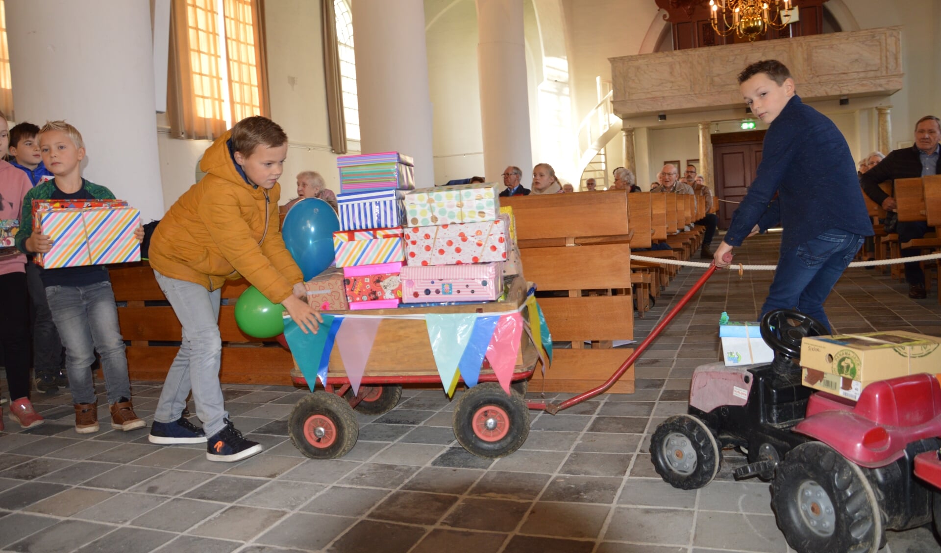Kinderen brengen de vele schoenendozen in de kerk. Het totaal kwam uit op 195 dozen. Foto: Marlies Groeneveld