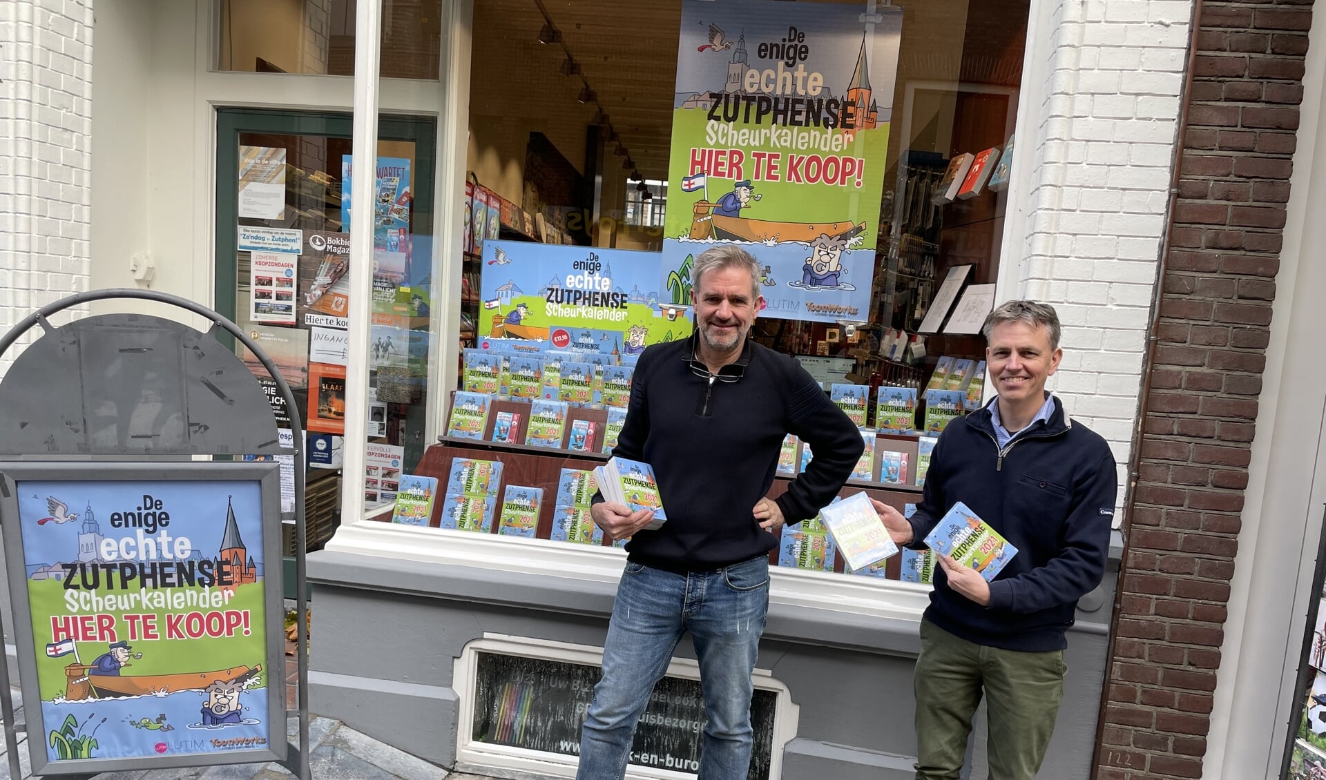 Han Nieuwenhuis en Johan Aalpoel van Boek en Buro van den Brink zijn zeer te spreken over de kalender en hebben de complete etalage ermee ingericht. Foto: PR