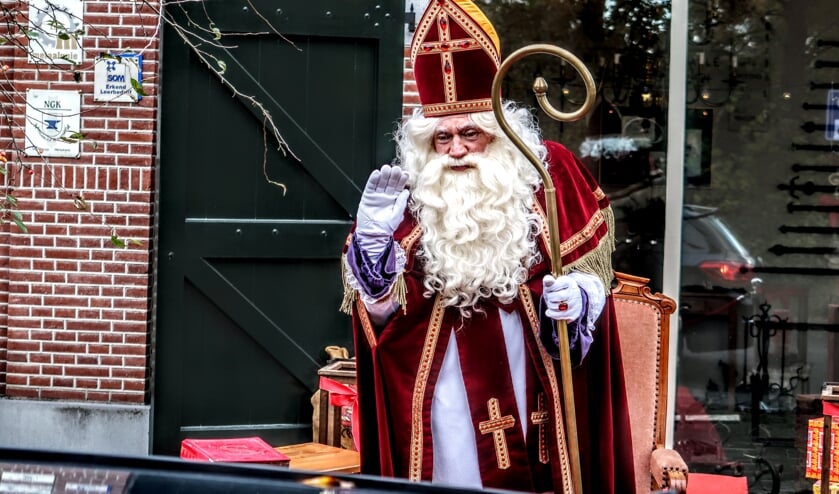 <p>Sinterklaas zwaait de hele middag naar de kinderen die in auto's langs hem rijden tijdens de Sinterklaas-drive through. Foto: Luuk Stam</p>