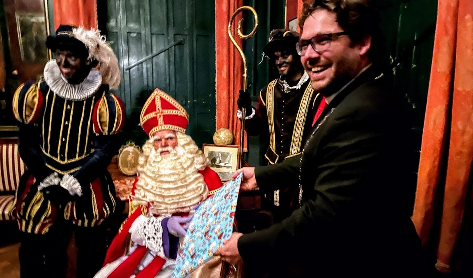 De rollen zijn even omgedraaid. Burgemeester Sebastiaan van 't Erve heeft een cadeautje voor Sinterklaas. Foto: Henri Bruntink