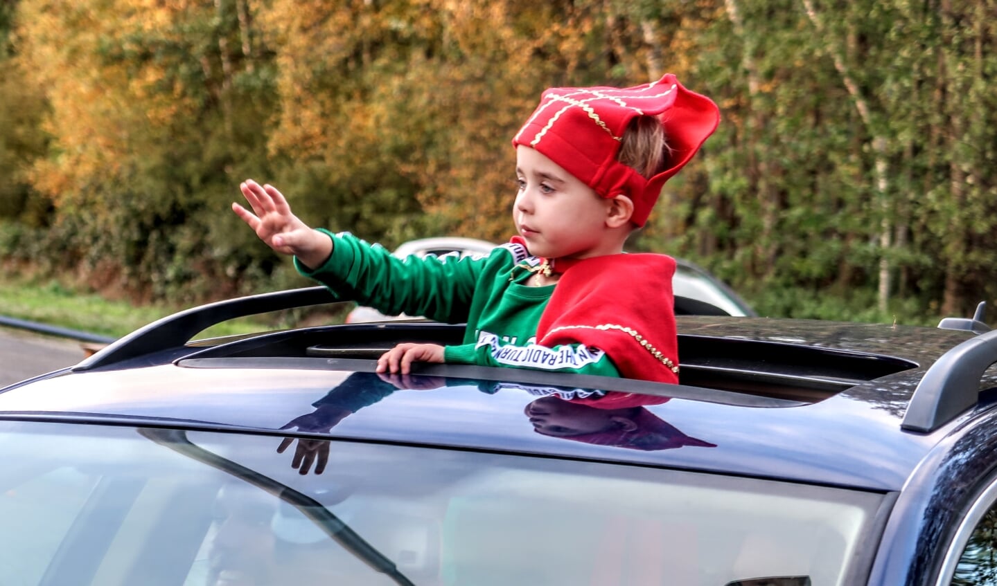 Via het open dak van de auto wordt gezwaaid naar Sinterklaas in de Sinterklaas-drive through. Foto: Luuk Stam