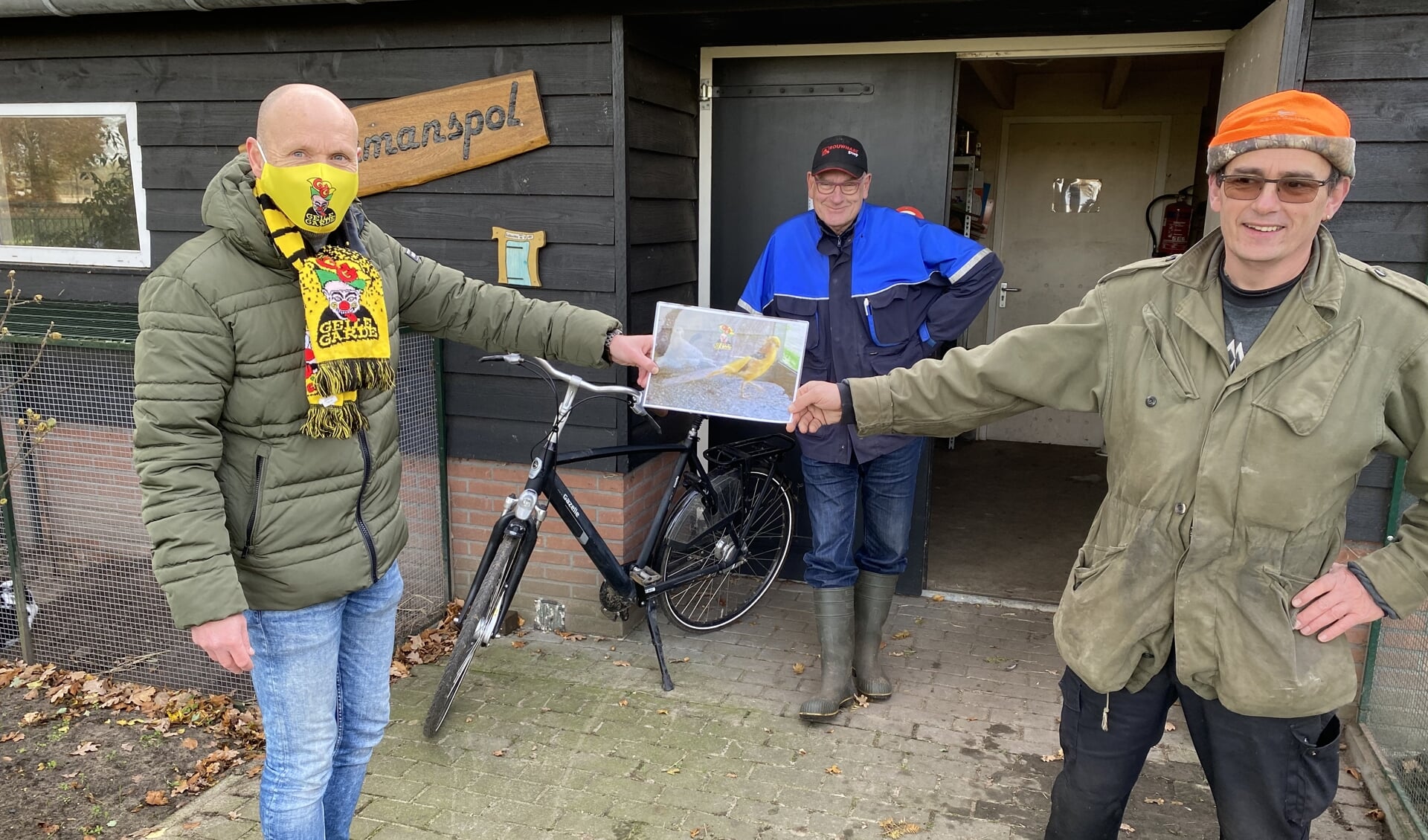 Foto: Giso Rijks van de Geile Garde (l) heeft zojuist de gele goudfazant aangeboden aan Arnold Bleumink van dierenpark De Halve Maan. Op de achtergrond kijkt beheerder Bennie Klein Tank toe. Foto: PR