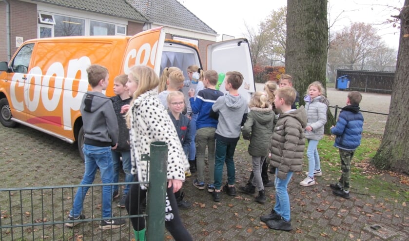 <p>De kinderen mochten helpen het Coop-busje vol lege flessen te stoppen.. Foto: PR</p>
