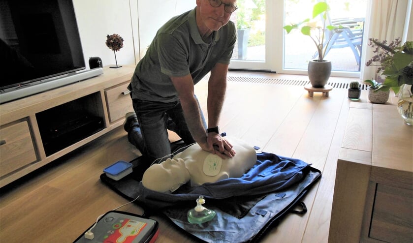 Joop van Berkel demonstreert in zijn huiskamer een AED. “Snel gebruik van dit apparaat verhoogt de overlevingskans na een hartstilstand aanzienlijk.”  Foto: Eric Klop                  