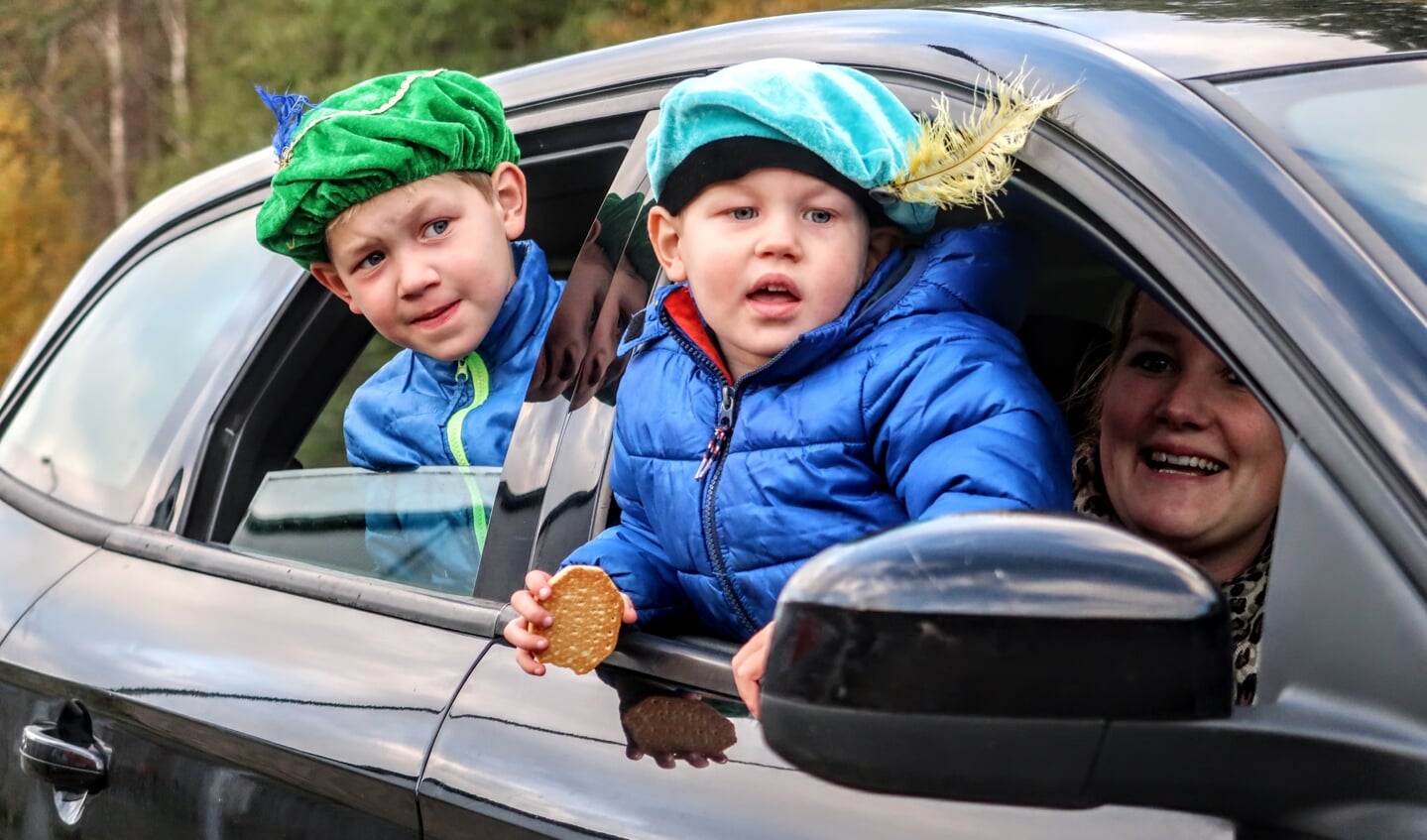 Via het raam van de auto kijken naar Sinterklaas in de Sinterklaas-drive through. Foto: Luuk Stam