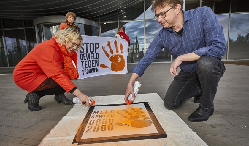 Jokelien Homans en wethouder Henk van Zeijts brengen het logo aan bij het gemeentehuis in Lochem. Foto: Arjan Gotink
