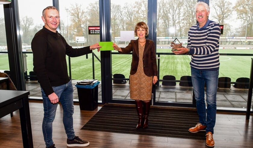 Wethouder Tineke Zomer overhandigt de cadeaubonnen aan voorzitter Leon Klein Tank van de Stichting Sportpark Jaspers. FC Winterswijk-voorzitter Gerrit te Kolste heeft net de bokaal in ontvangst genomen. Foto: Evert Braakhekke.